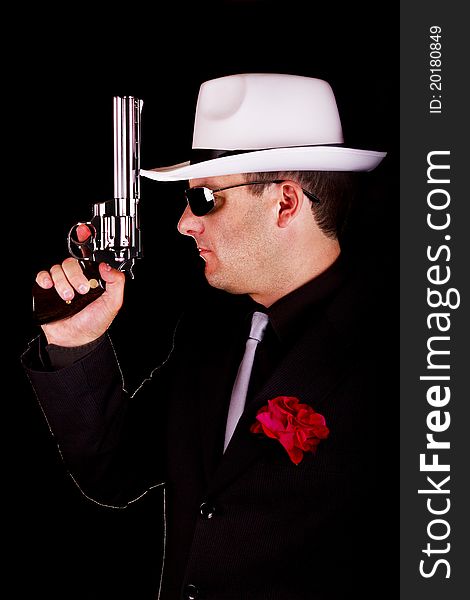 View of a dark suit gangster man holding a gun. View of a dark suit gangster man holding a gun.