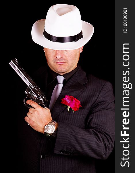 View of a dark suit gangster man holding a gun. View of a dark suit gangster man holding a gun.