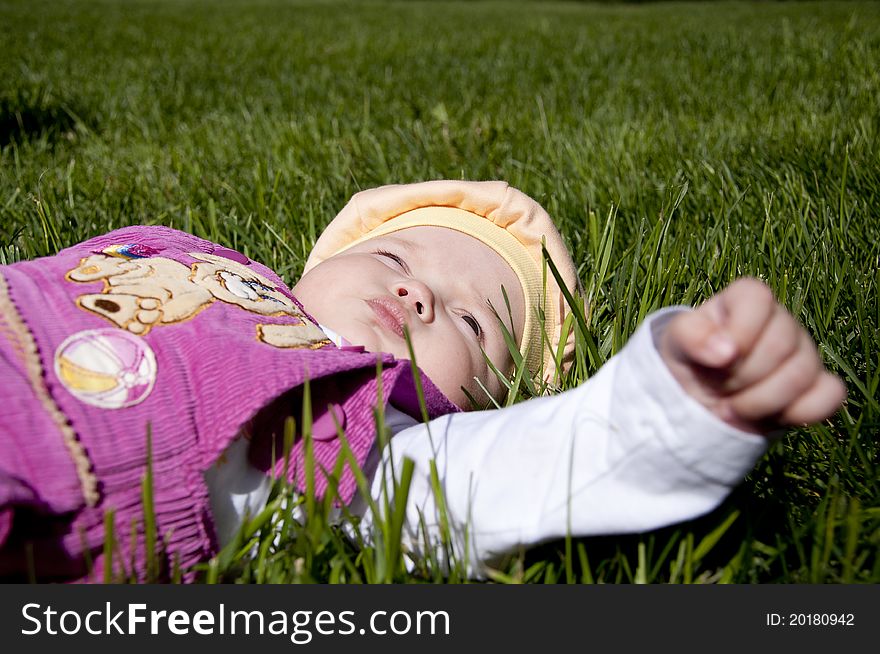 The portrait of the kid, lays on grass