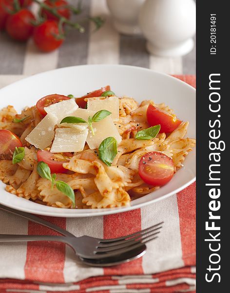 Farfalle in tomato sauce with basil and grated parmesan. Farfalle in tomato sauce with basil and grated parmesan