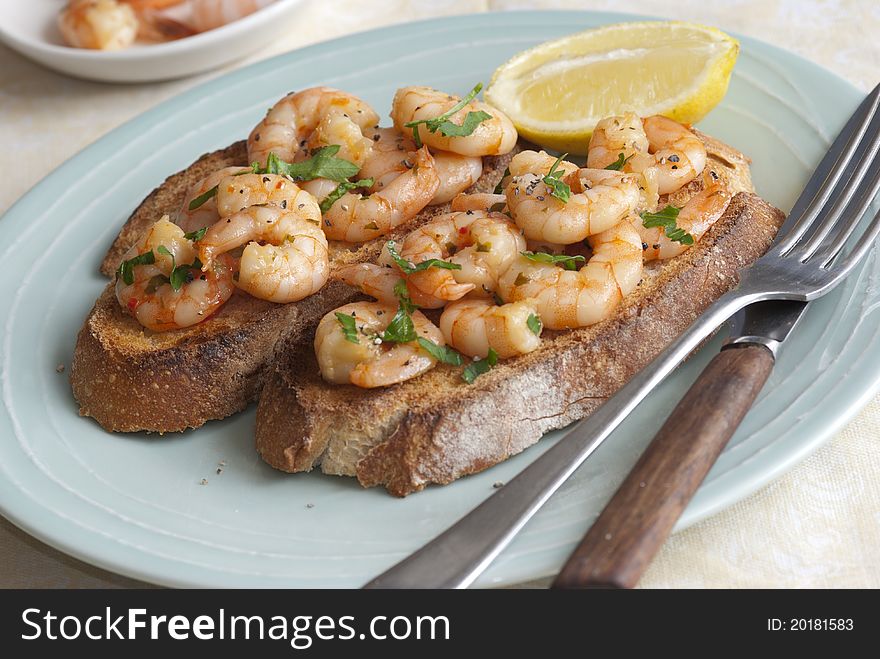 Toasted sourdough topped with king prawns and herbs. Toasted sourdough topped with king prawns and herbs