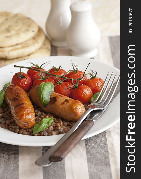 Pork sausages with green lentils and roasted cherry tomatoes