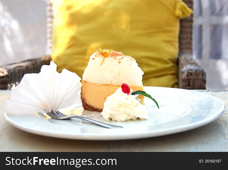 Slice of lemon meringue pie on white plate with cream