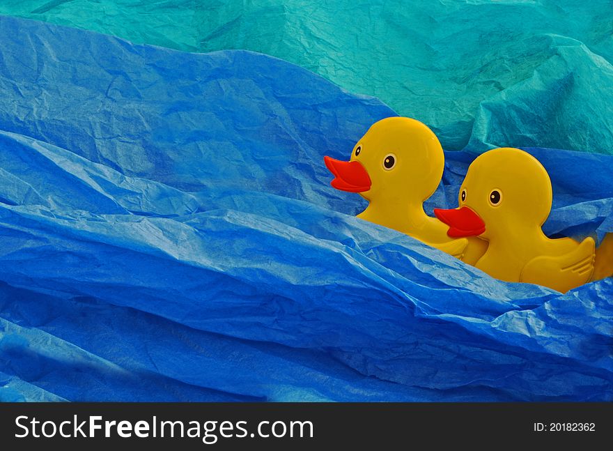Two yellow ducks on a blue and aqua background. Two yellow ducks on a blue and aqua background