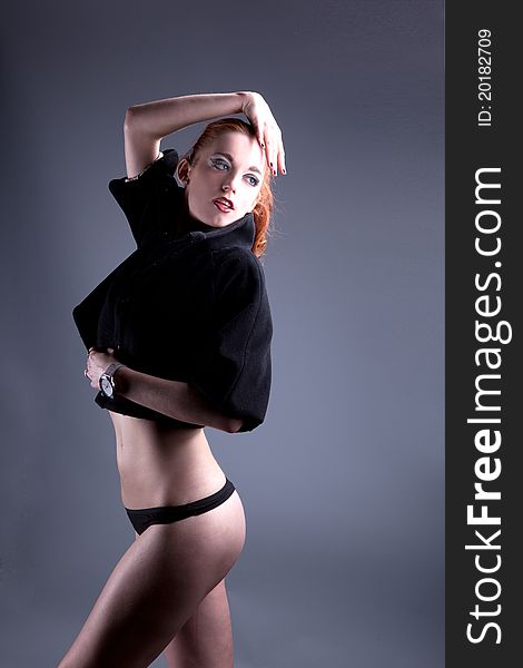 Beautiful red-haired girl in a black short cape in his underwear with the vulgar make-up