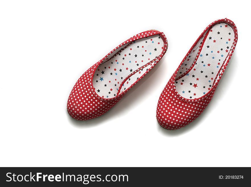 A pair of stylish flat shoes, with polkadotted pattern, isolated on white background.