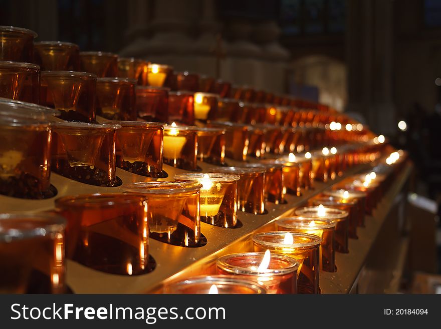 Soft light radiating from candles lit in prayer at a church. Soft light radiating from candles lit in prayer at a church