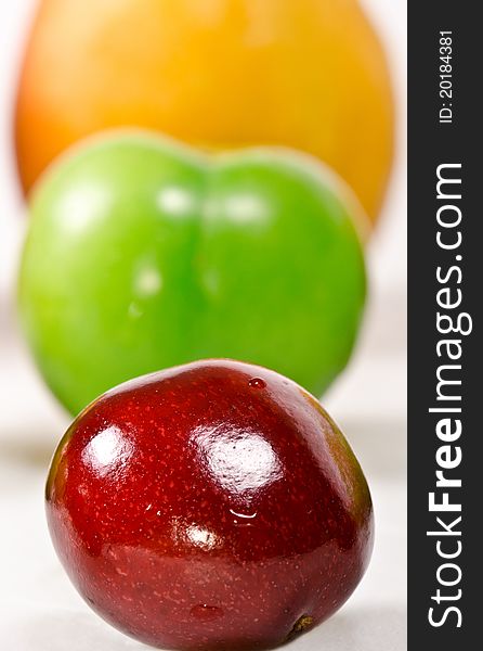 Three in a row; cherry, plum and apricot on a white background