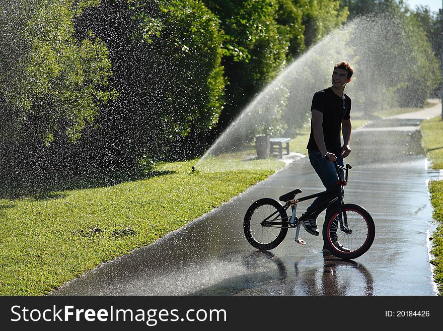 Boy With Bmx Stay On Fountain Splashes Background
