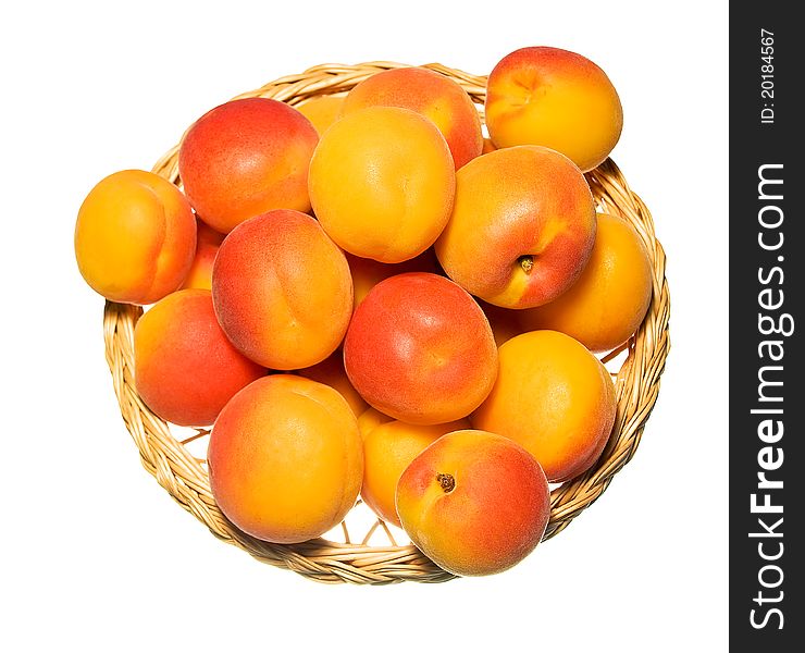 Basket full of apricots isolated on white top view