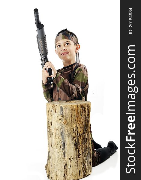 A young elementary soldier in army camouflage, poised with his machine gun behind an old tree stump. Isolated on white. A young elementary soldier in army camouflage, poised with his machine gun behind an old tree stump. Isolated on white.