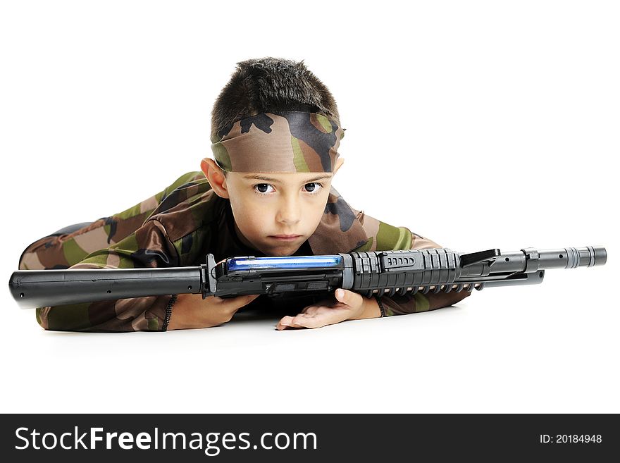 A serious young boy in army camoflage, crawling on his belly with a black machine gun. Isolated on white. A serious young boy in army camoflage, crawling on his belly with a black machine gun. Isolated on white.