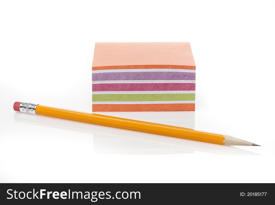 A colorful note pad with a pencil against a white background