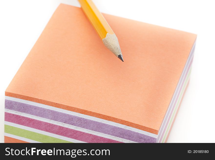 A colorful note pad with a pencil against a white background