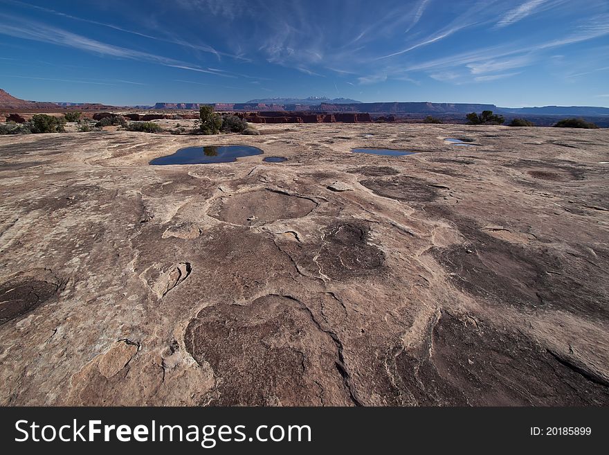 In the White Crack area of the White Rim Road in the Canyonlands National Park, the vistas are spectacular.  The La Sal Mountains can be seen again in the distance.  Filled water pockets can be seen, ans also evidence of airplanes flying haphazardly above, leaving their intriguing  design  of jet trails. In the White Crack area of the White Rim Road in the Canyonlands National Park, the vistas are spectacular.  The La Sal Mountains can be seen again in the distance.  Filled water pockets can be seen, ans also evidence of airplanes flying haphazardly above, leaving their intriguing  design  of jet trails.