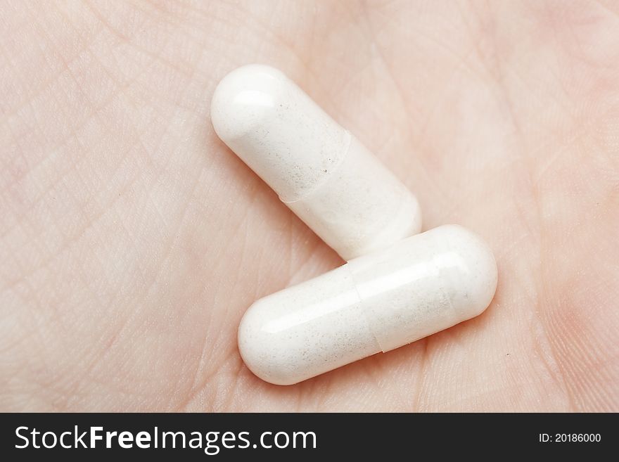 White pills pouring into a persons hand
