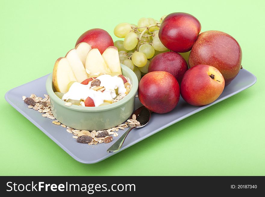 Studio-shot of a plate with fresh fruits, muesli and yogurt. plate full with grapes, nectarines and apple. Studio-shot of a plate with fresh fruits, muesli and yogurt. plate full with grapes, nectarines and apple.