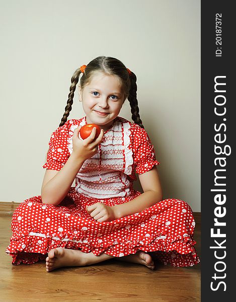 An image of a nicel little girl with a tomato. An image of a nicel little girl with a tomato