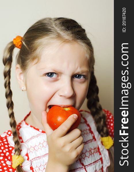 An image of a nicel little girl with a red tomato. An image of a nicel little girl with a red tomato