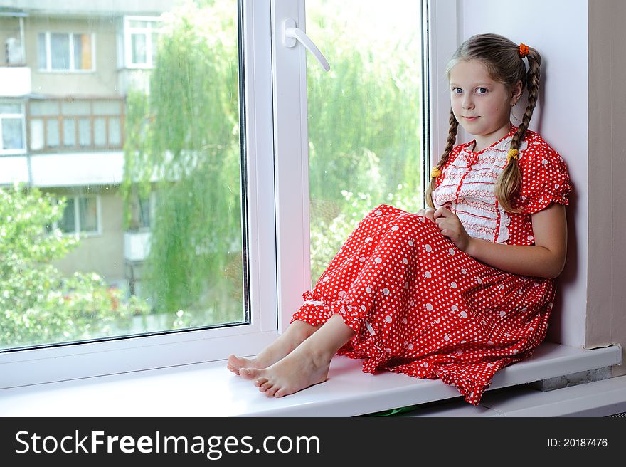 An image of a nicel little girl on the window