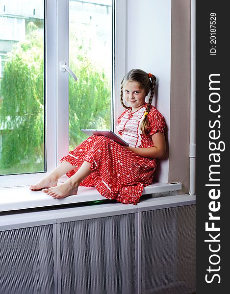 An image of a beautiful little girl on the window. An image of a beautiful little girl on the window