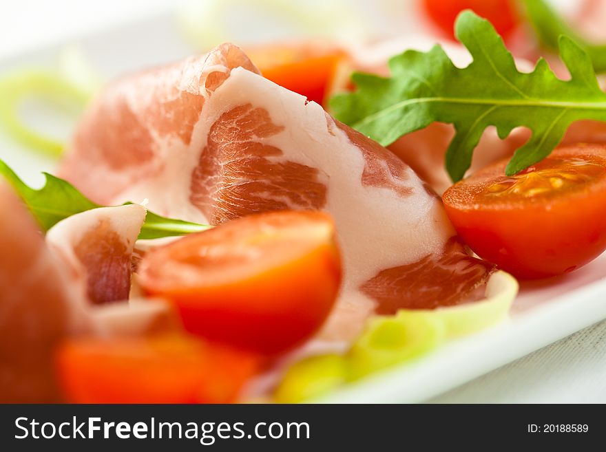 Sliced coppa(italian cuisine)with cherry tomatoes and rocket salad. Sliced coppa(italian cuisine)with cherry tomatoes and rocket salad