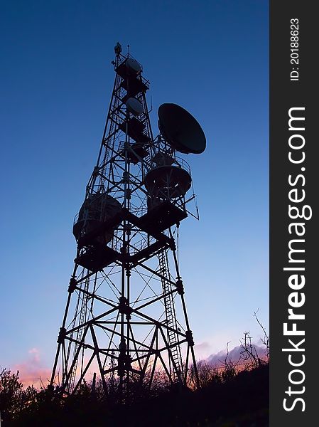 Silhouette of mobile phone communication antenna tower on night sky background