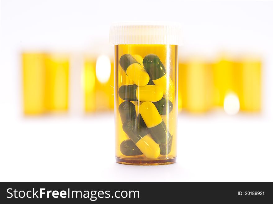 Pill Containers with Green and White capsules inside, all on a bright white background