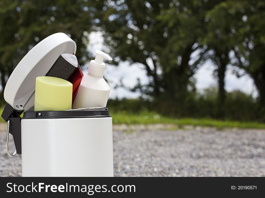 Cosmetic bottles thrown away in the white bin. Cosmetic bottles thrown away in the white bin