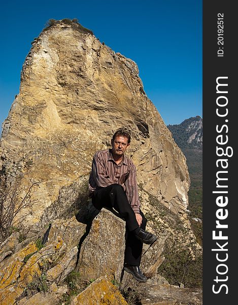 Man sitting on a rock in the mountains. Man sitting on a rock in the mountains