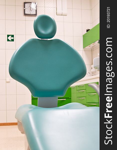 Big green dental chair in dental clinic