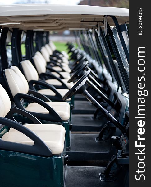 Photograph of a row of golf carts on a course.