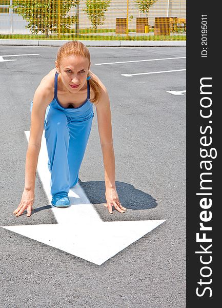 Athletic woman in start position on track