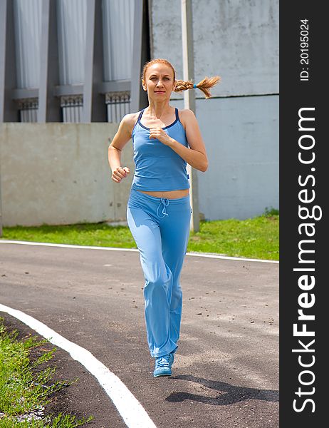 Young Woman Jogging In The Park In Summer