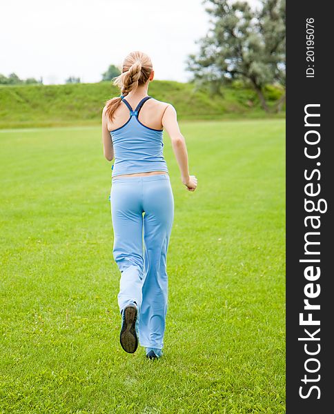 Young woman jogging in the park in summer