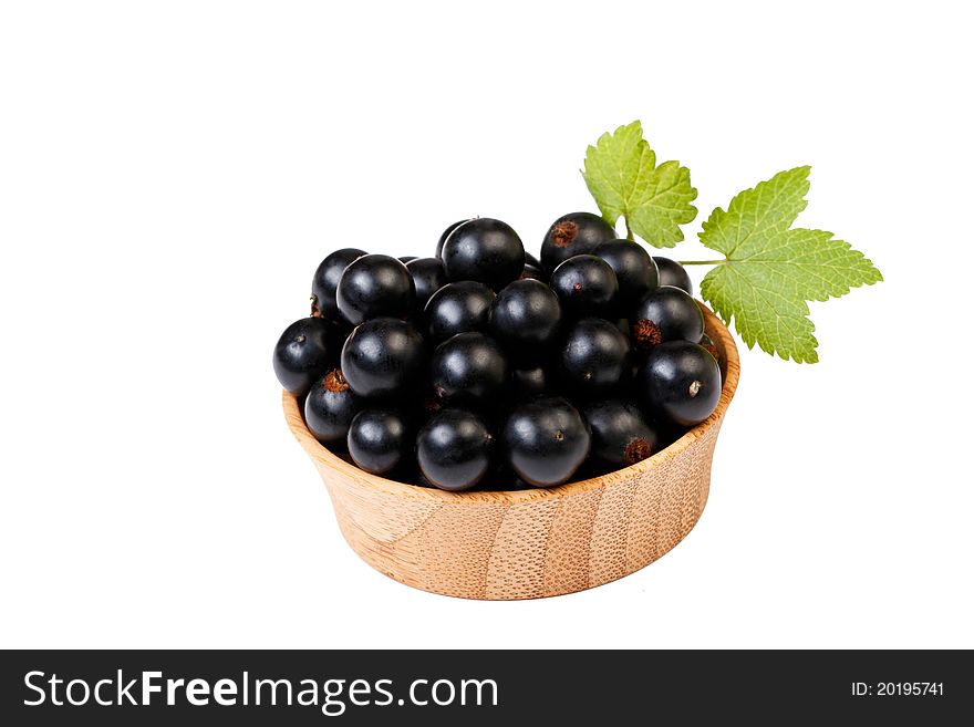 Blackberries in a wooden bowl, with green leafes