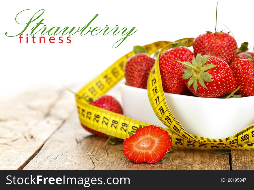 Closeup of a bowl with strawberries and a measure tape with place for your text on the left. Closeup of a bowl with strawberries and a measure tape with place for your text on the left