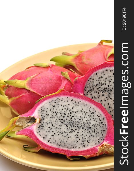 Vertical shot cut dragon fruit on plate with white background and text space. Vertical shot cut dragon fruit on plate with white background and text space