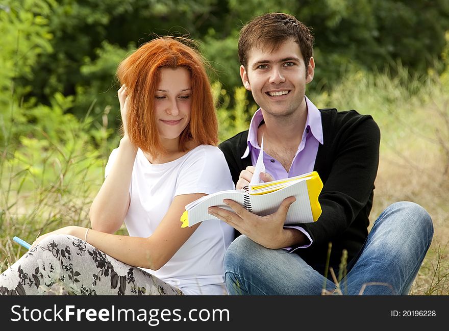 Two students at outdoor doing homework.