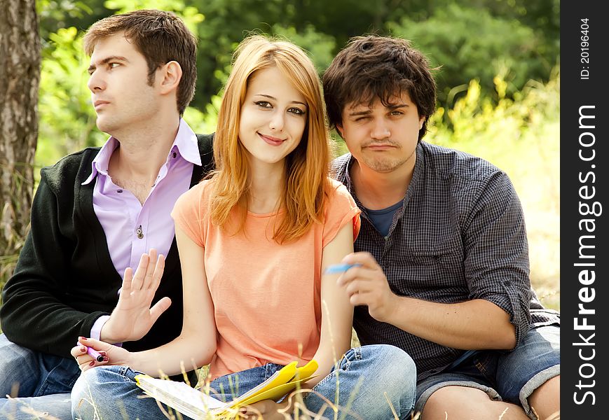 Three students at outdoor doing homework.