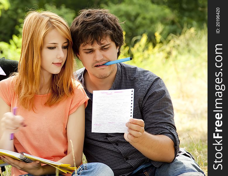 Two students at outdoor doing homework.