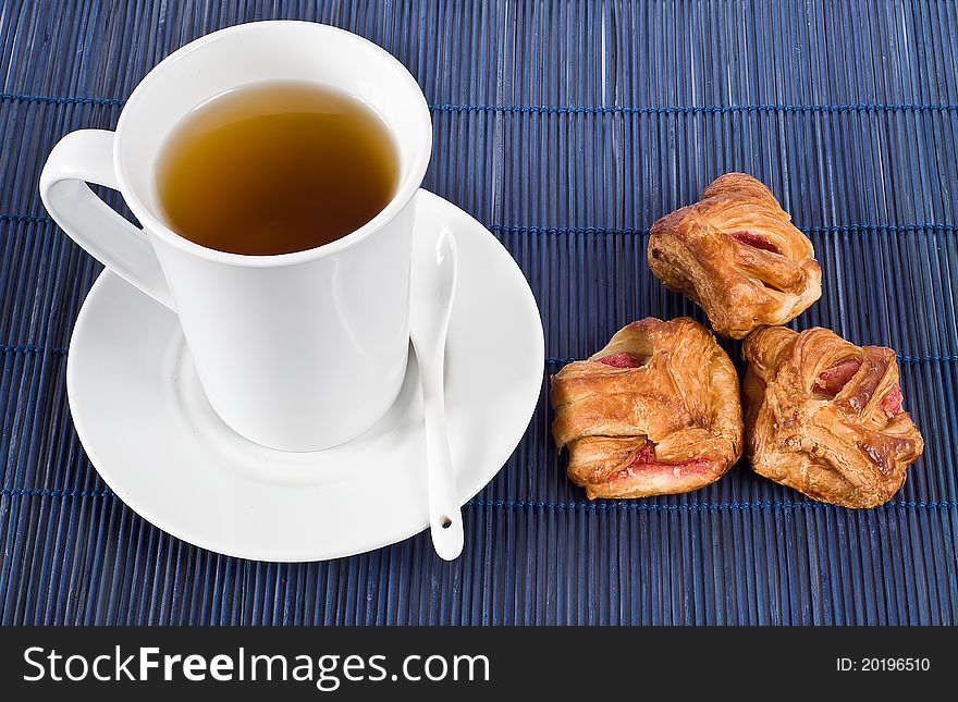 The picture shows a cup of tea with biscuits. The picture shows a cup of tea with biscuits