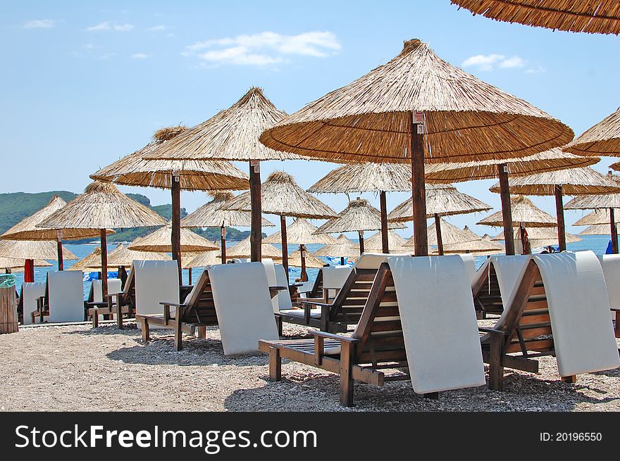 Straw umbrellas and chairs on Adriatic Sea coast. Straw umbrellas and chairs on Adriatic Sea coast