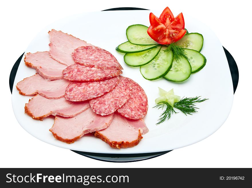 Sliced salami and ham with cucumber and tomato on a plate isolated on a white background. Sliced salami and ham with cucumber and tomato on a plate isolated on a white background