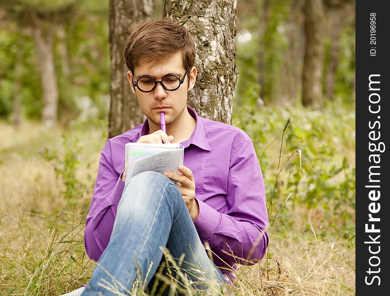 Funny Men With Glasses Doing Homework At The Park