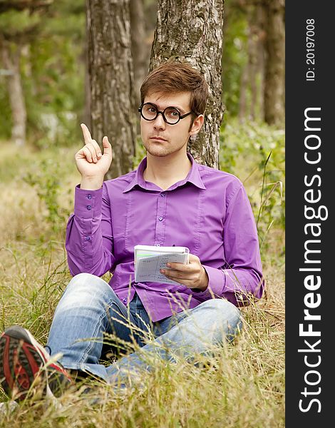 Funny men with glasses doing homework at the park.