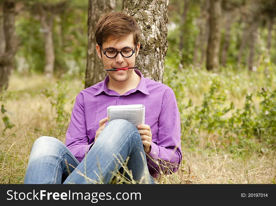 Funny men with glasses doing homework at the park.