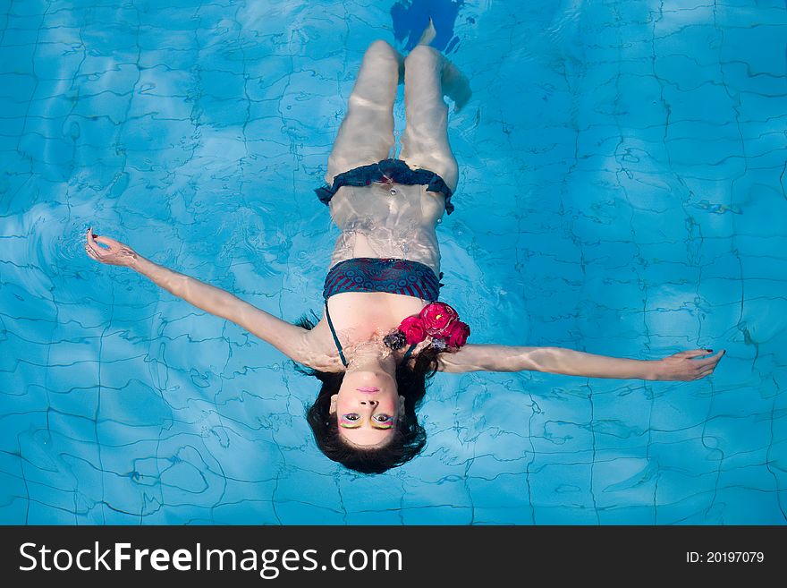 Woman In Bikini Floating In Swimming Pool