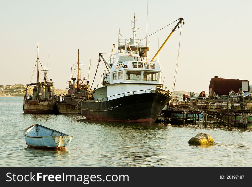 Lonely boat at the pier of old ships