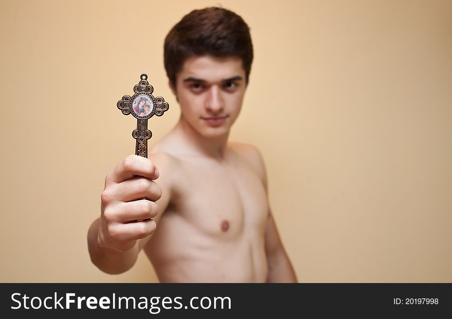 Guy holding cross and looking directly at it